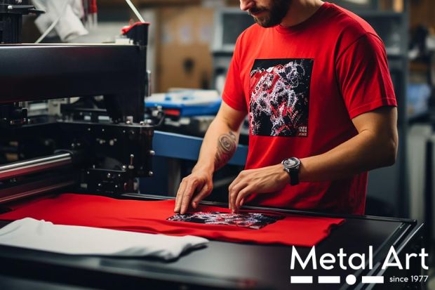Personalizzazione e stampa magliette a Milano per le Aziende: lavoratore mentre utilizza la macchina da stampa per magliette